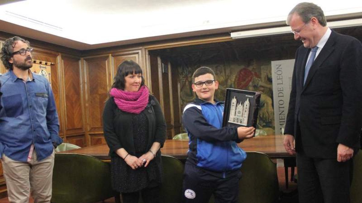 El alcalde de León, Antonio Silván, entrega a David Cubillas un cuadro con la Catedral de León en presencia de sus padres. RAMIRO