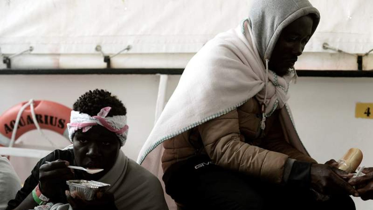 Dos de los inmigrantes que viajan a bordo del ‘Aquarius’ comiendo su ración diaria. KARPOV