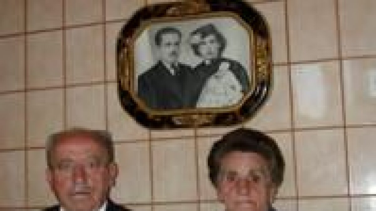 Laudelino y Avelina posan bajo la foto del día de sy boda, hace hoy medio siglo