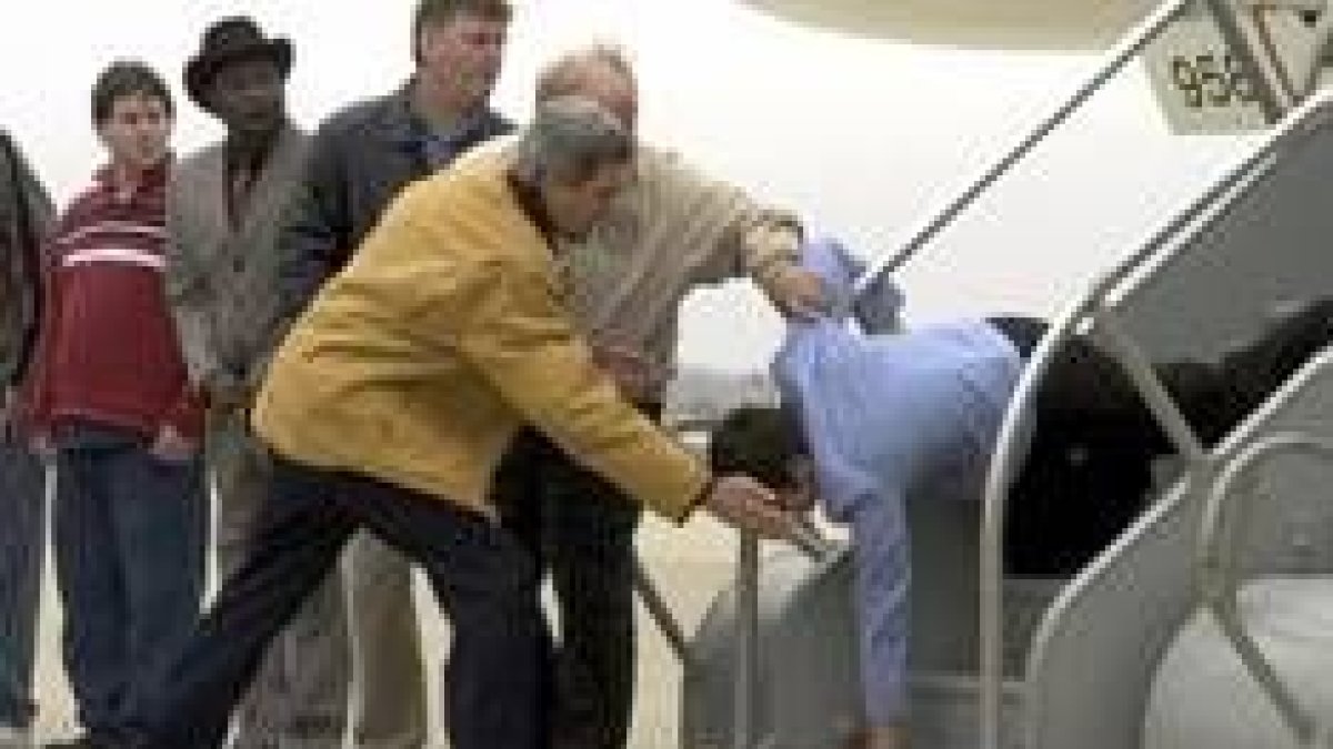 Kerry ayuda a una integrante de su equipo que se cayó en las escalerillas del avión del candidato