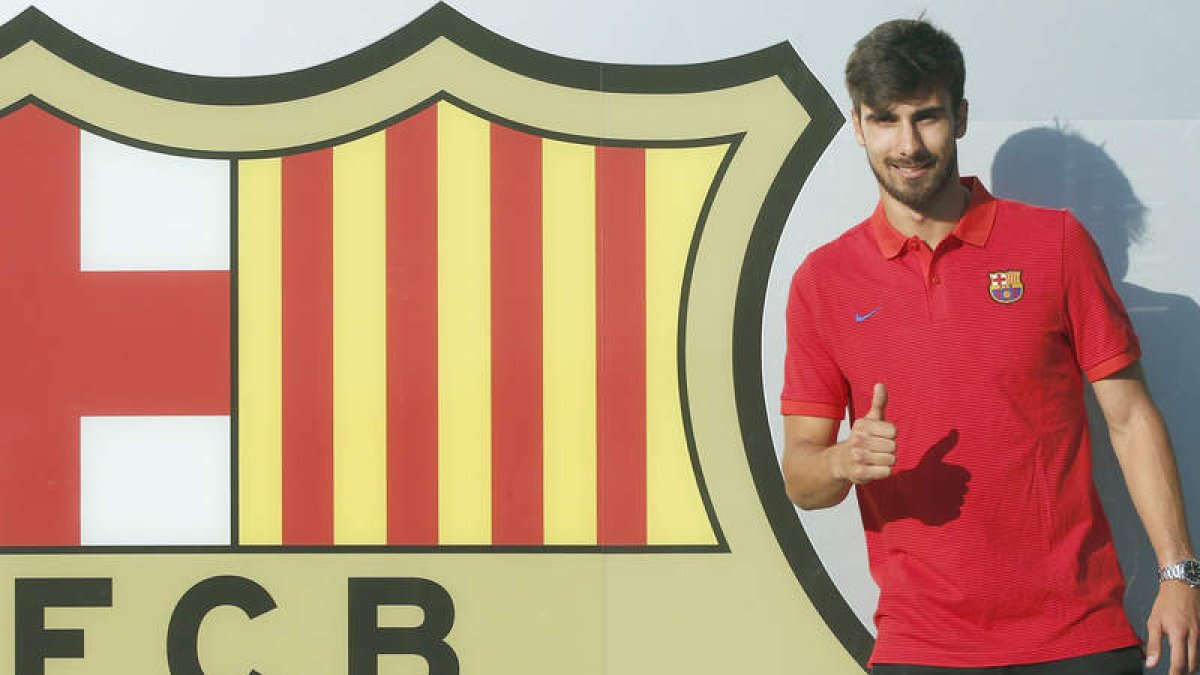 André Gomes posa junto al escudo del Barcelona después de su presentación como nuevo jugador azulgrana. ANDREU DALMAU