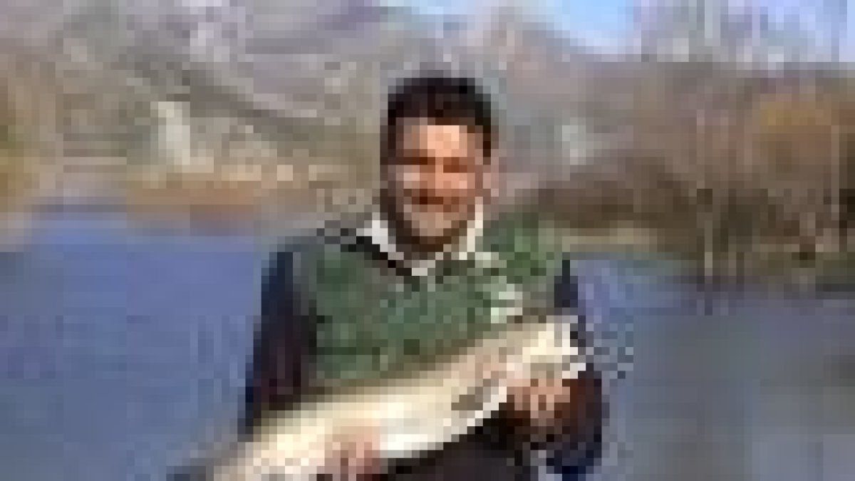 Luis Javier Álvarez, vecino de Mallo de luna, posa con su trofeo en el pantano