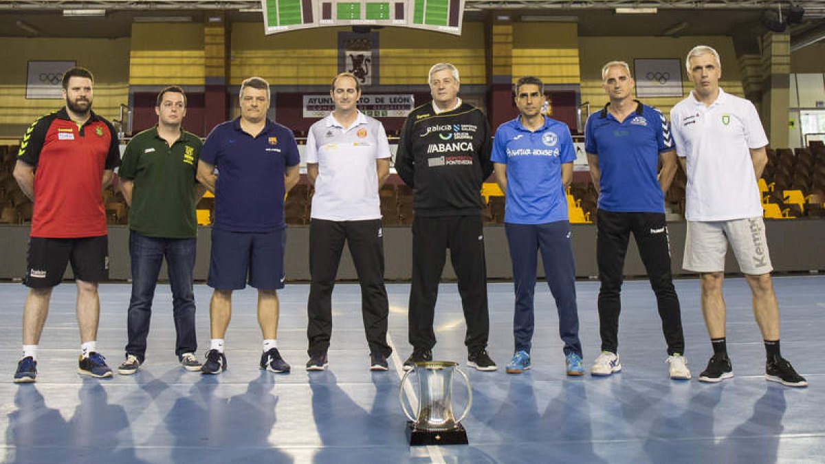 Los ocho entrenadores que pujan por la Copa del Rey que se juega en León posaron ayer en el centro del Palacio de Deportes con el trofeo. FERNANDO OTERO PERANDONES