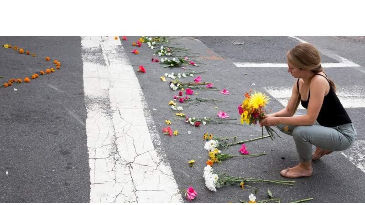 Una mujer coloca flores en el lugar de los hechos. TASOS KATOPODIS