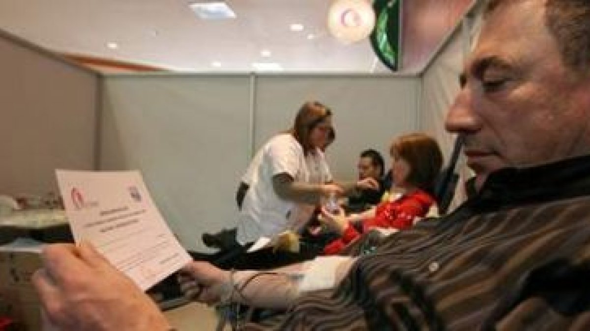 Uno de los donantes durante la extracción de la sangre y con la entrada de cine en la mano, ayer en