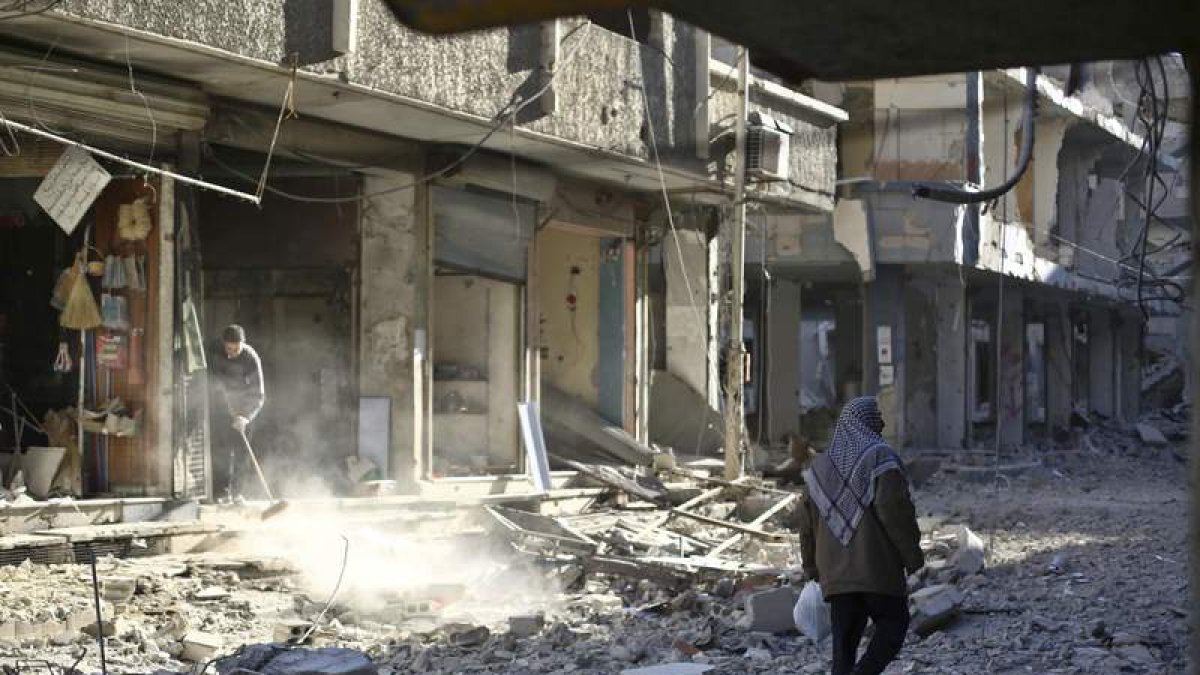 Un hombre camina entre los escombros de un edificio.
