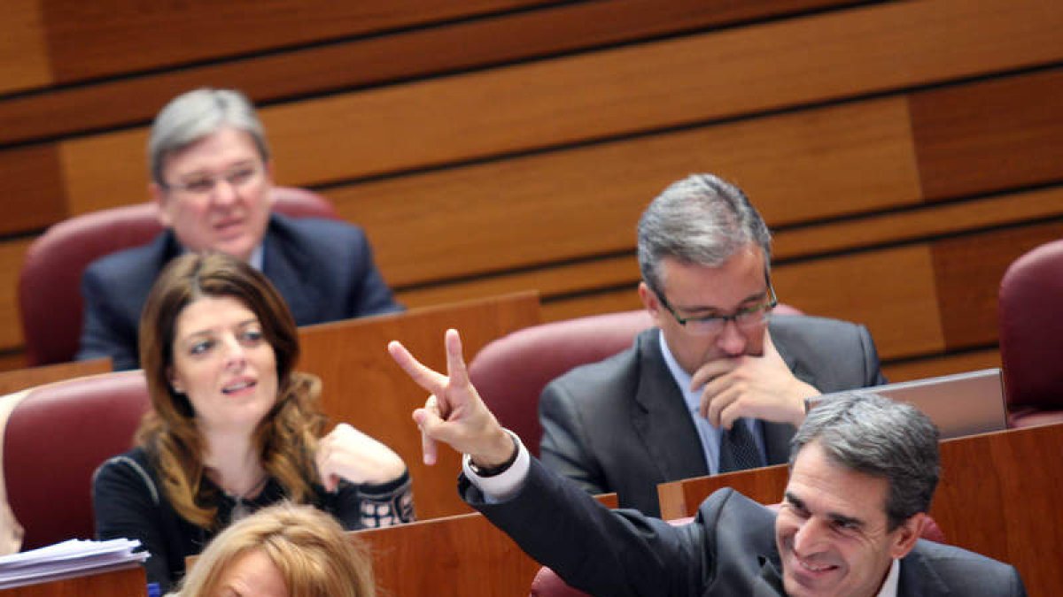 El procurador del PP Juan José Sanz Vitorio hace el gesto de la victoria durante el pleno de las Cortes de Castilla y León.