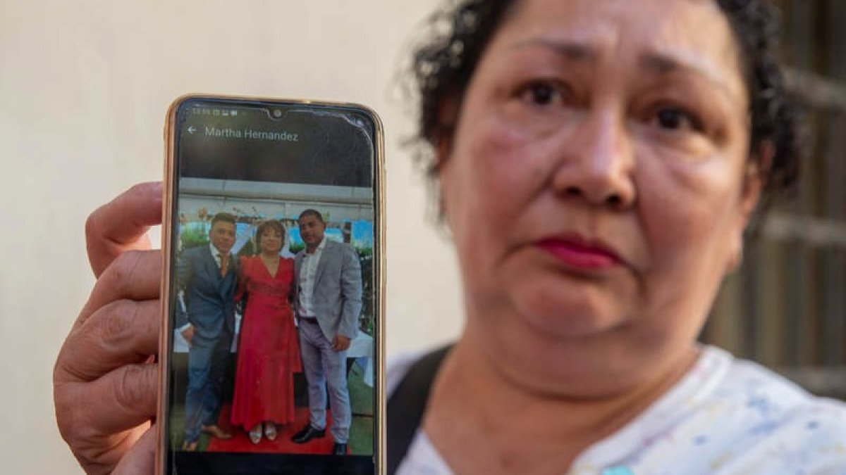 Una mujer muestra a su hermana y sobrinos, desaparecidos en el incendio. MARCIAL GUILLÉN