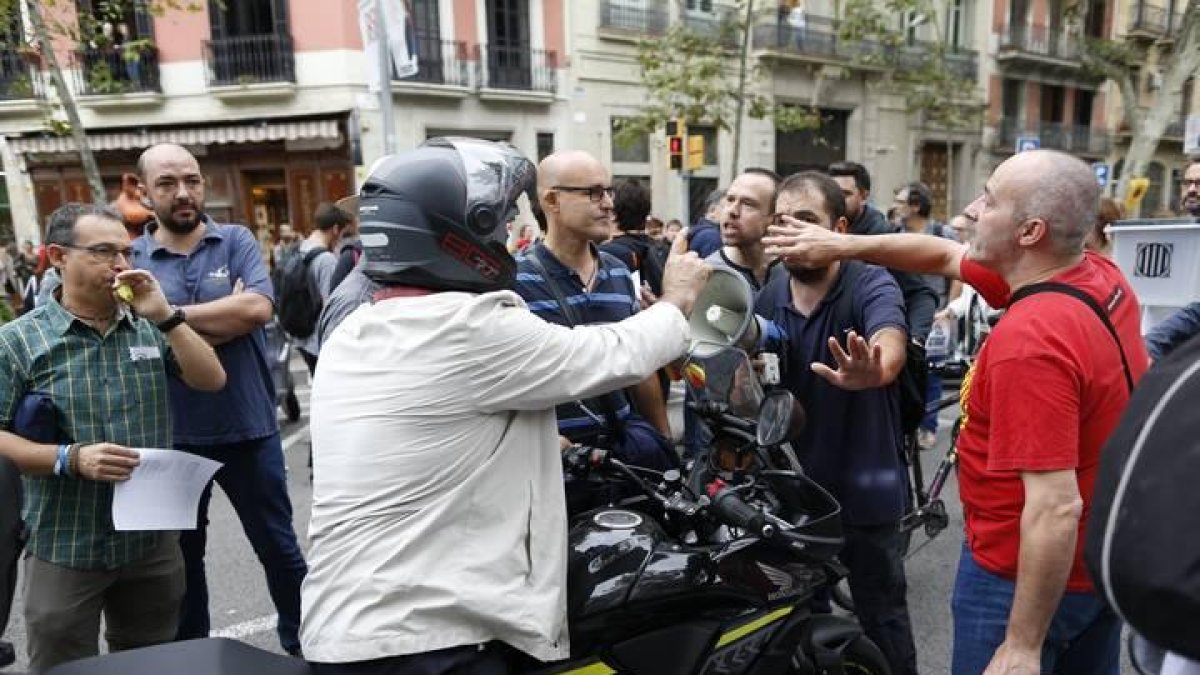 Discusión entre un grupo de personas que cortan una calle en Barcelona y unos motoristas que quieren seguir circulando.