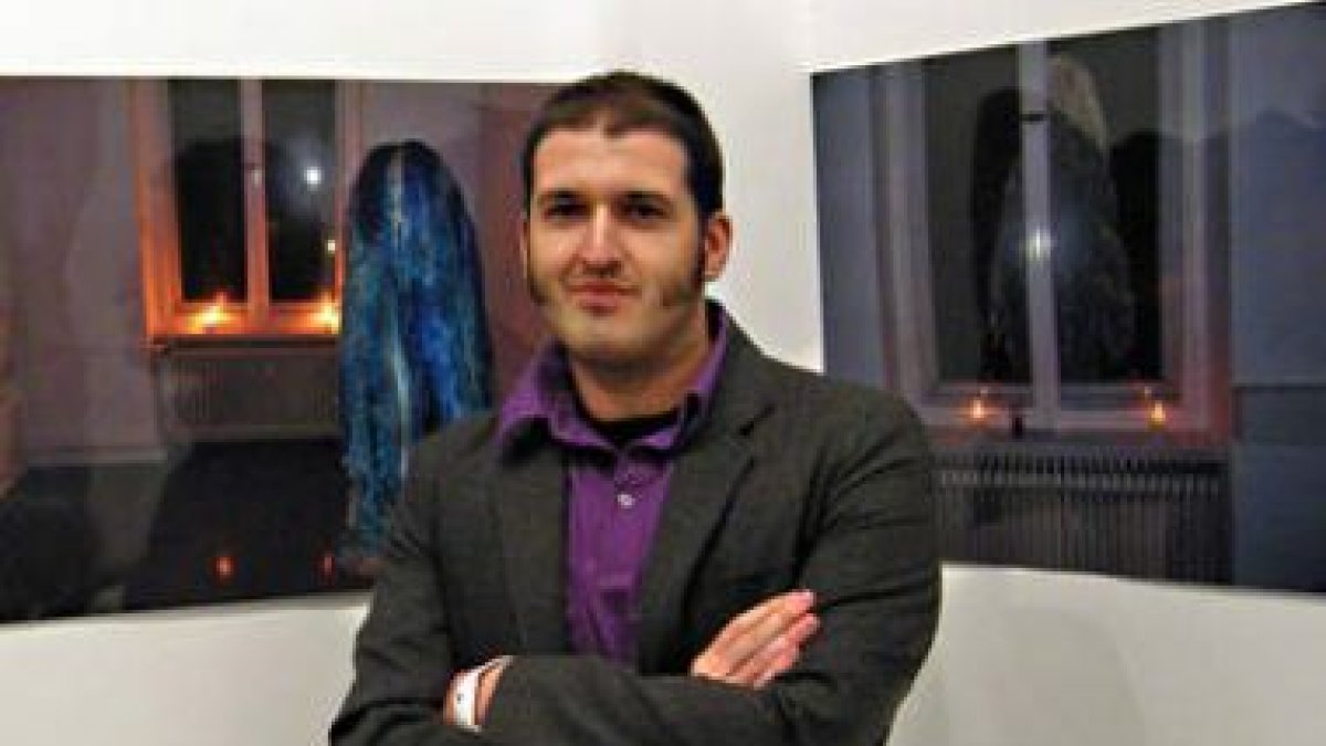 Miguel Ángel Tornero posa junto a dos de sus fotografías