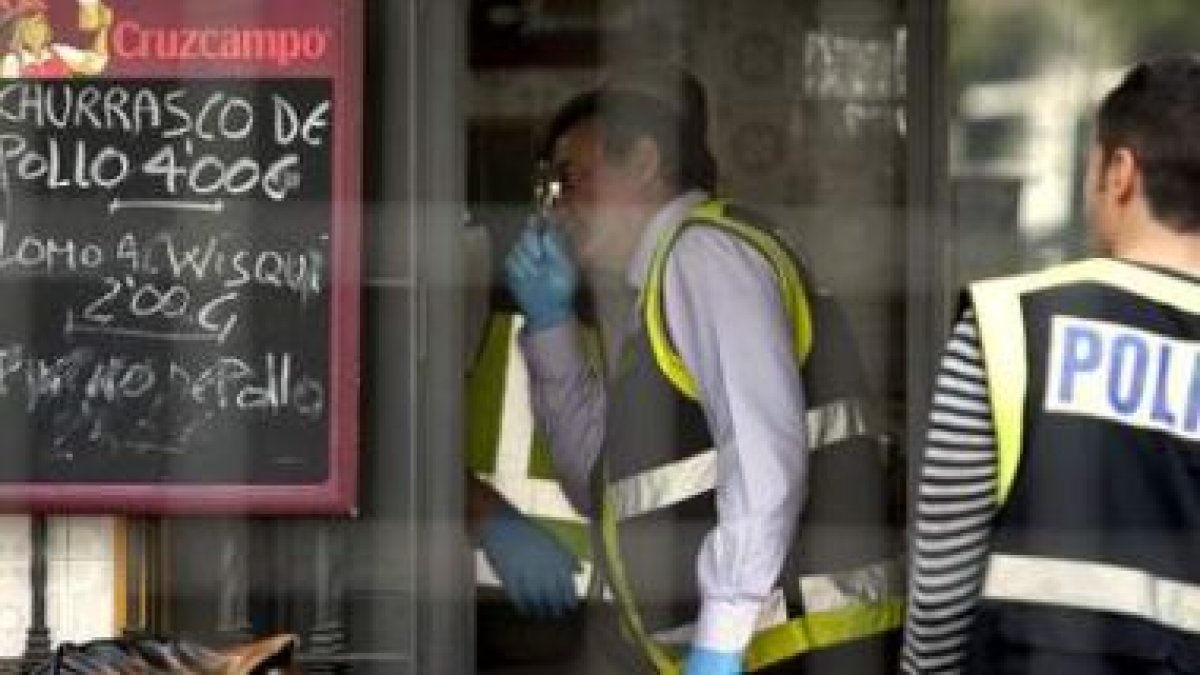 La policía científica busca pruebas en el bar donde fue asesinado su propietario.