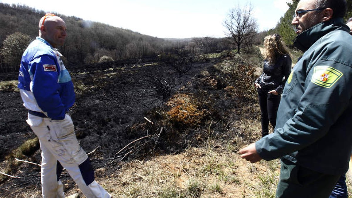 Varios vecinos comentan con un agente forestal las consecuencias del incendio que ayer arrasó 600 hectáreas en su municipio.