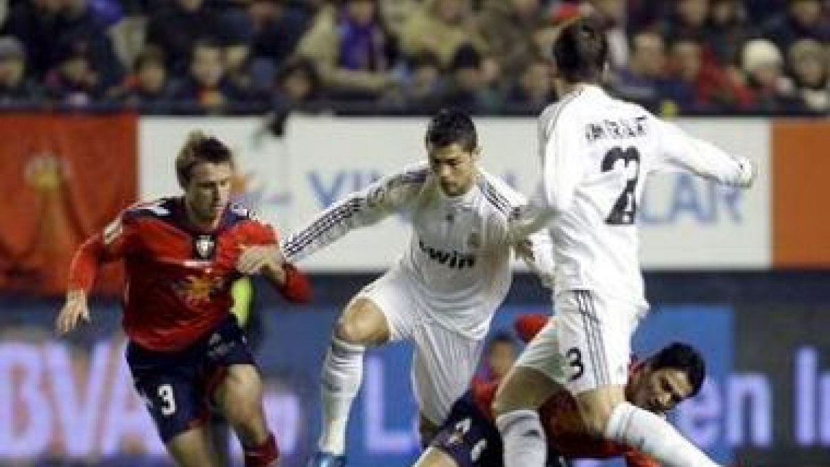 Cristiano Ronaldo regatea a los jugadores del Osasuna Ignacio Monreal y Javad Nekounam.