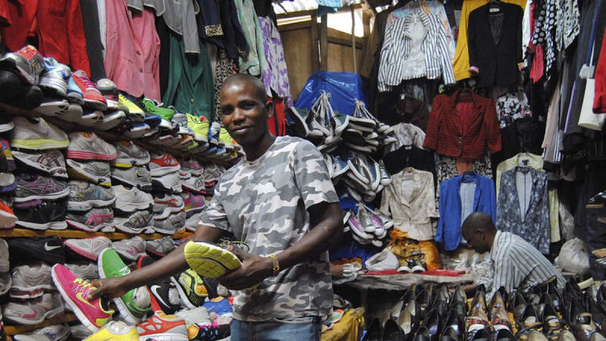 Un vendedor del Toy Market, de Nairobi, en su puesto de zapatillas usadas.