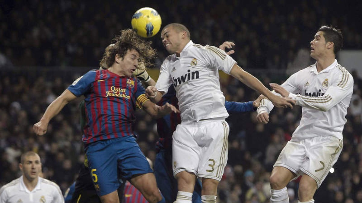Puyol y Pepe saltan para cabecear el balón. Los dos defensas tendrán hoy trabajo por delante.