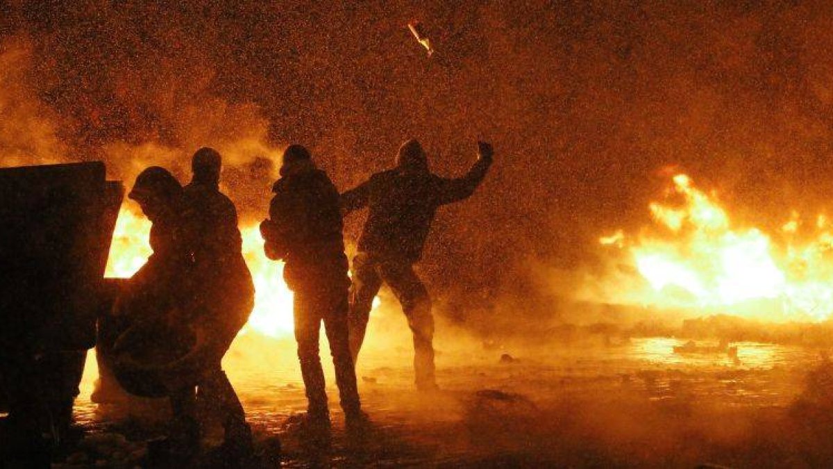 Manifestantes lanzan cócteles molotov durante los enfrentamientos con los antidisturbios, anoche en el centro de Kiev.