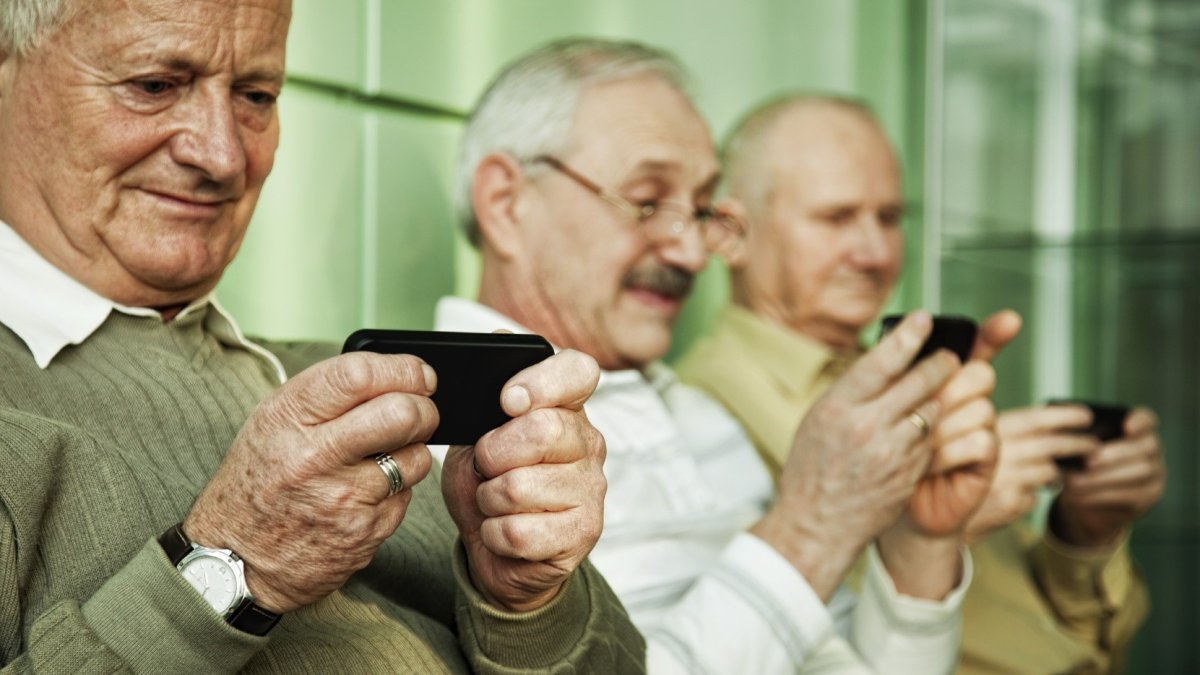Varios hombres manejan sus teléfonos móviles. ULE