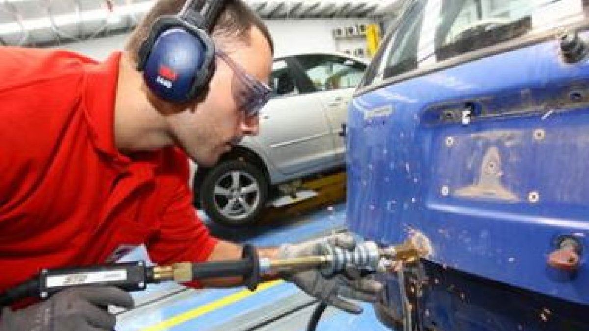 Un taller de coches en el que se está procediendo a la reparación de un automóvil.