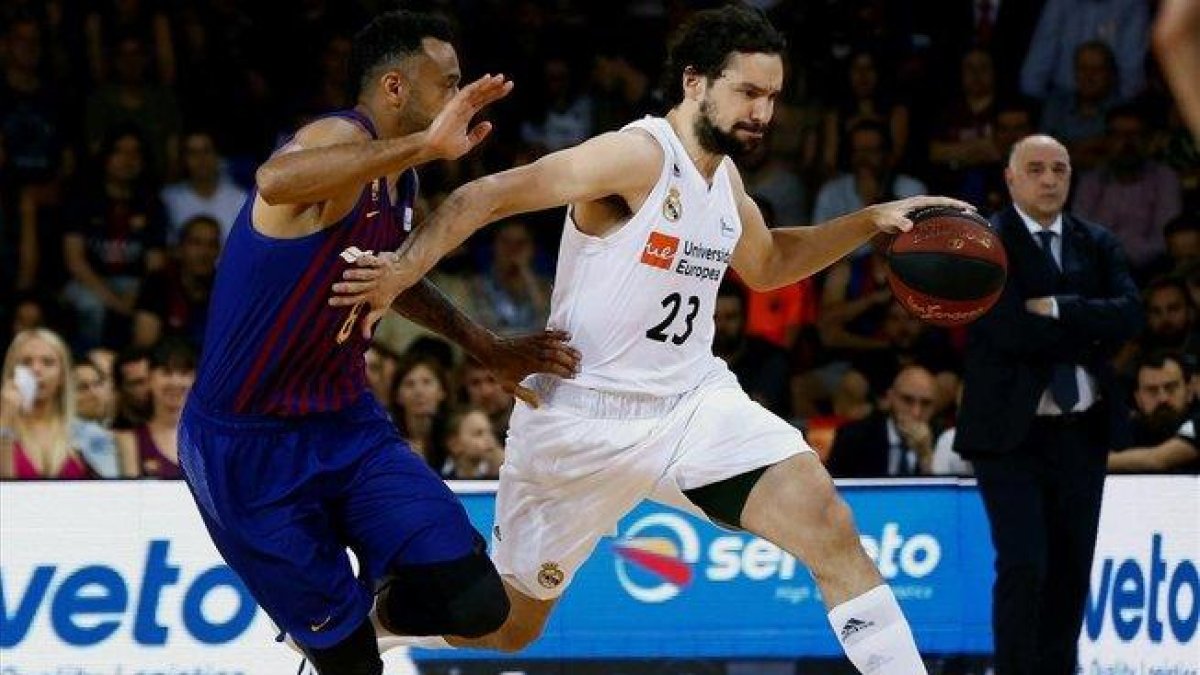 El madridista Llull empuja con la mano a Hanga, intentando evitar su defensa / ENRIC FONTCUBERTA (EFE)