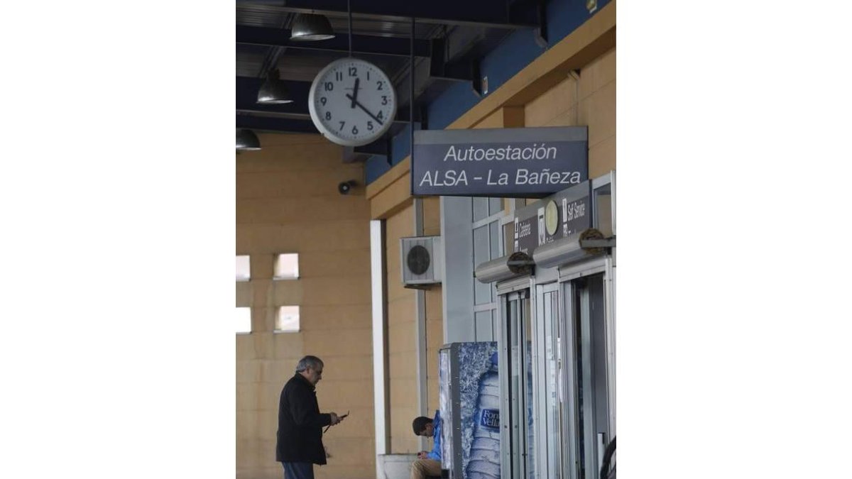 Dos viajeros esperan en la estación a mediodía de ayer.