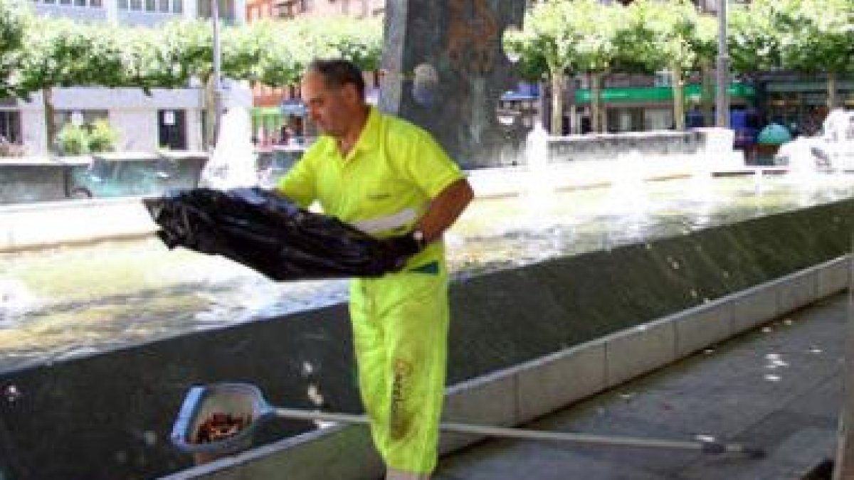 Un trabajador municipal limpiando la fuente de la plaza de las Cortes Leonesas, ayer.
