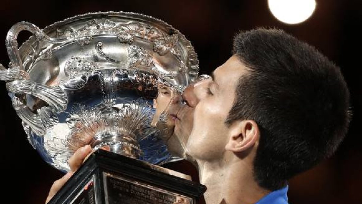 Novak Djokovic besa el trofeo que le acredita como campón del Abierto de Australia.