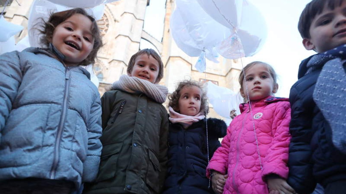 La plaza de la Catedral se convirtió ayer en el epicentro para reivindicar en León que se cumplan con los derechos de la infancia. Arriba varios niños y niñas con globos. Abajo, el acalde, Antonio Silván, con un grupo de escolares. RAMIRO / MARCIANO
