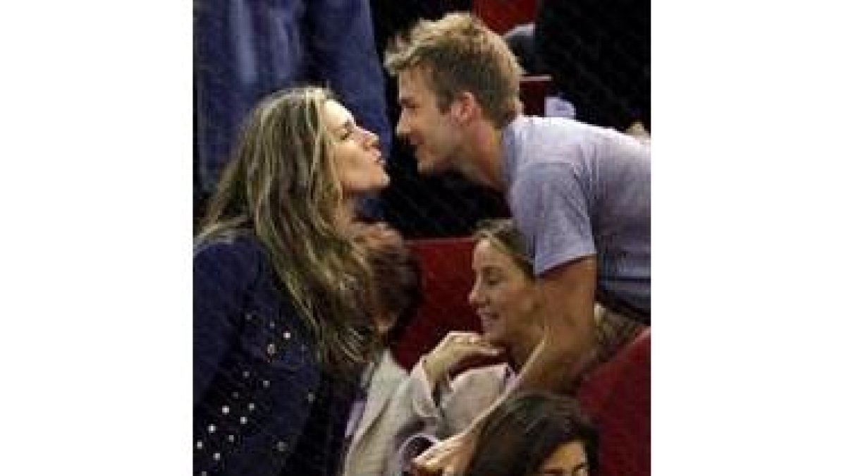 David Beckham besa a una admiradora durante un partido de tenis en Madrid