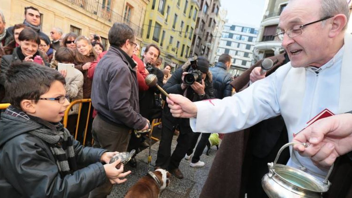 Un niño lleva a bendecir a su pajarillo
