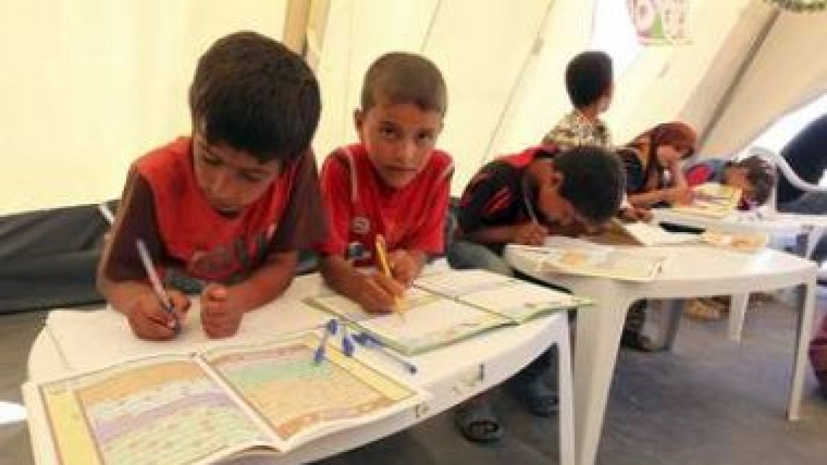 Niños libios que huyeron de la violencia van a clase en un campo de refugiados.