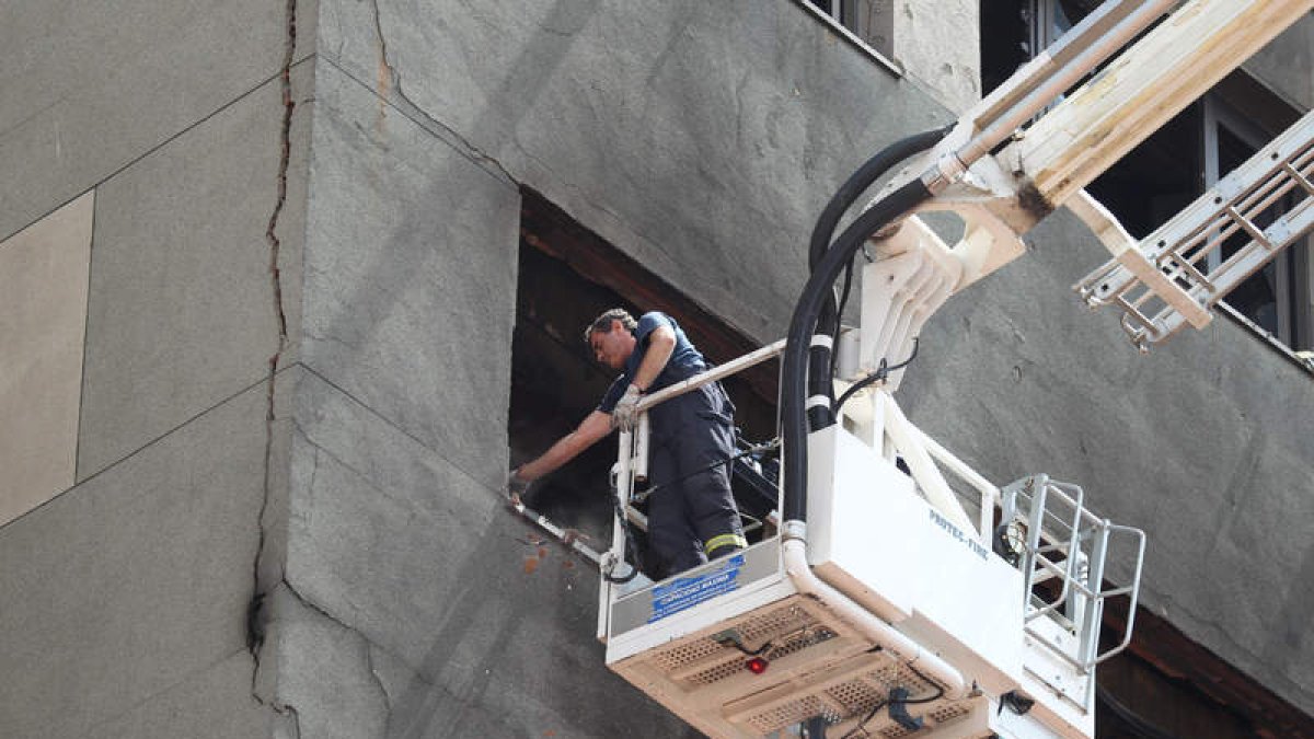 Un bombero revisando la grieta de la parte trasera del edificio municipal más siniestrado.