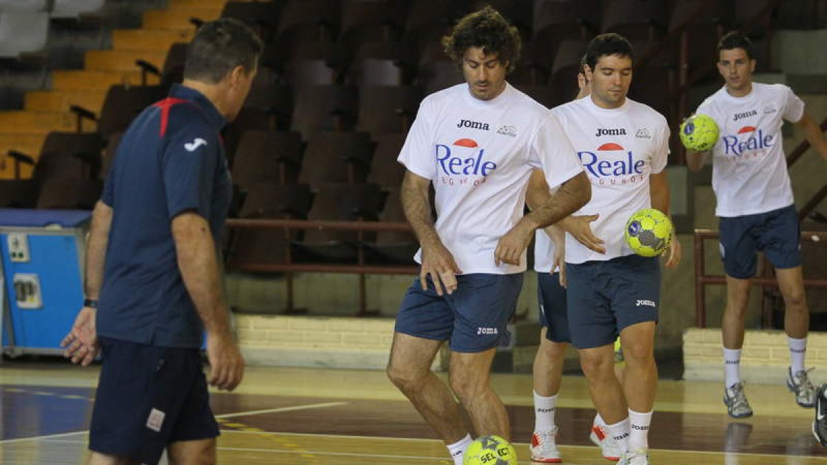 Los jugadores del Ademar con su entrenador, Manolo Cadenas, durante un entrenamiento.