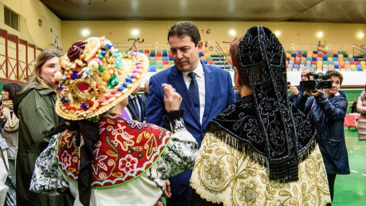 Alfonso Fernández Mañueco conversa con unas participantes del acto central de la XXXIV Semana Cultural de la Federación de Centros de Castilla y León en el País Vasco. JOSÉ ZORRILLA