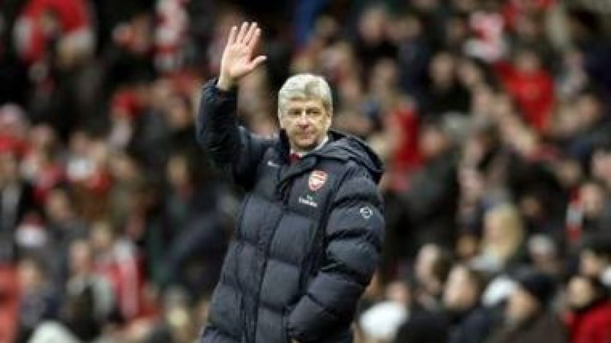 El entrenador del Arsenal, Arsene Wenger, saluda a los aficionados durante un partido.