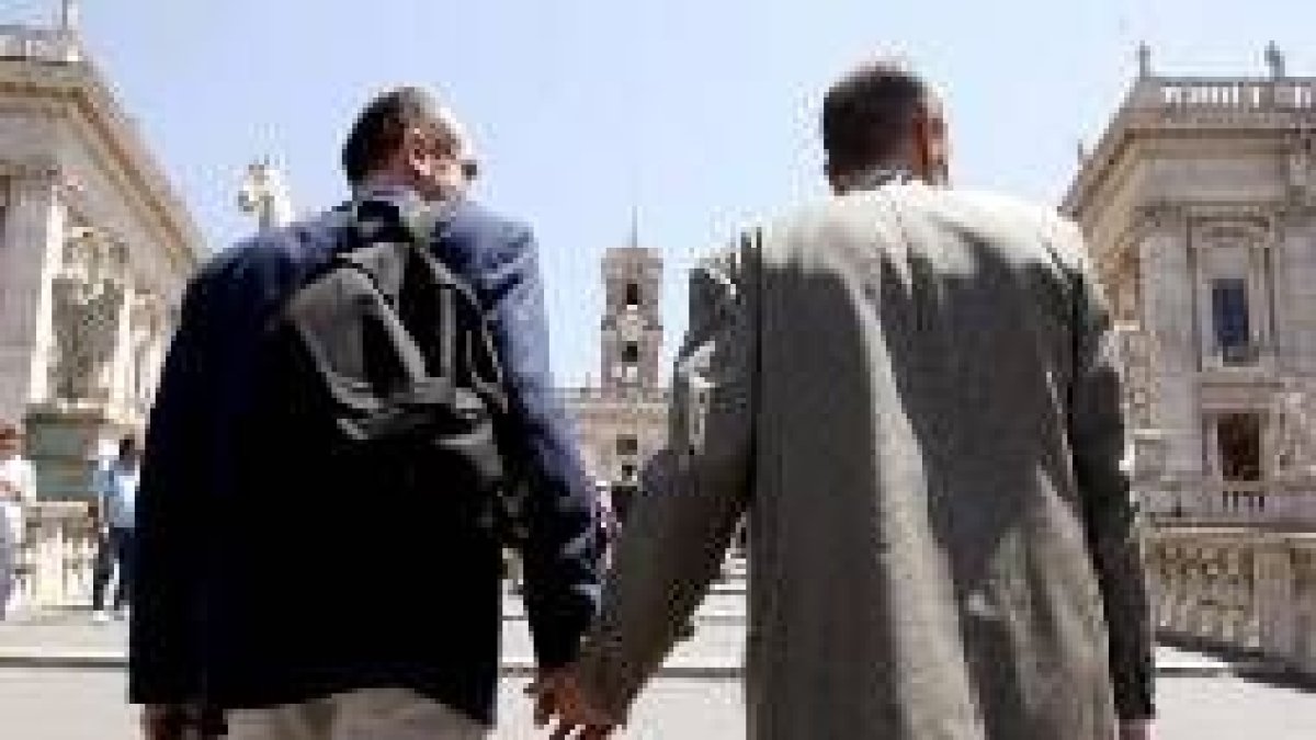 Una pareja homosexual camina de la mano hacia la plaza Campidoglio, en Roma