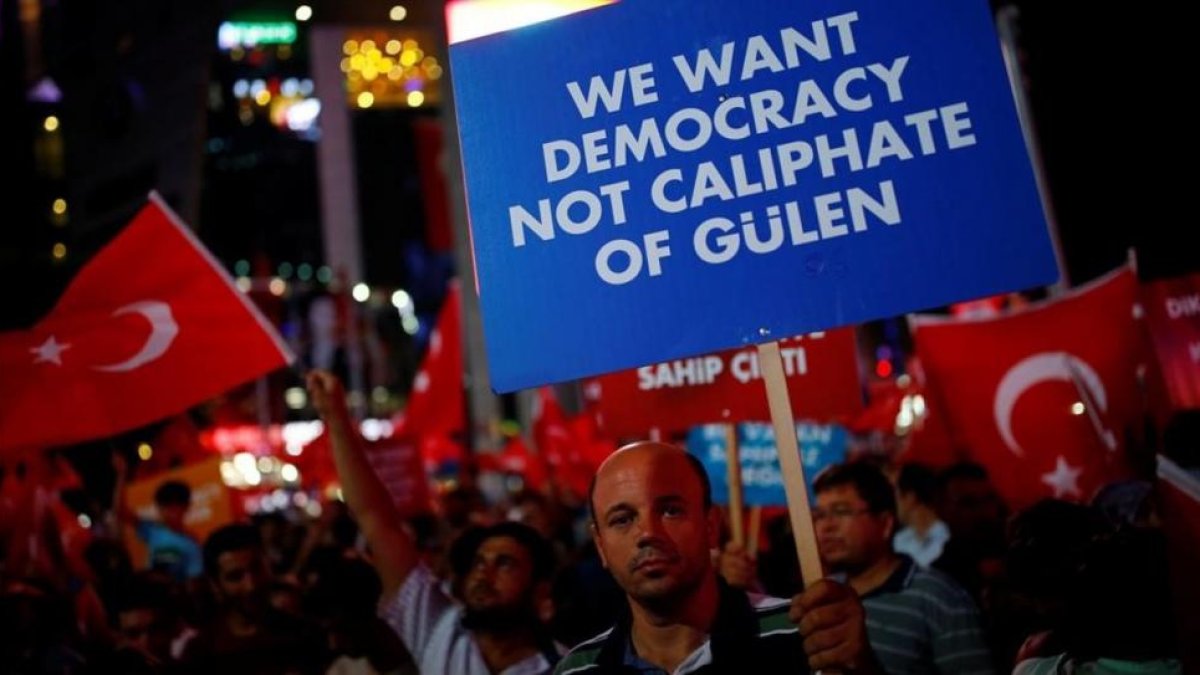 Un hombre sostiene un cartel junto a otros reunidos noche tras noche desde el 15 de julio, día del intento de golpe de Estado, en Ankara, el 27 de julio.