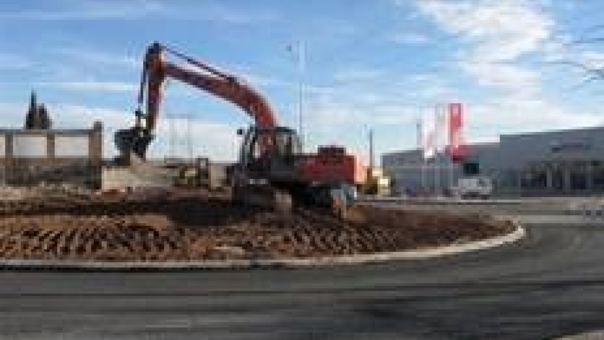 Una máquina excavadora trabaja para compactar la tierra utilizada en la creación de la rotonda