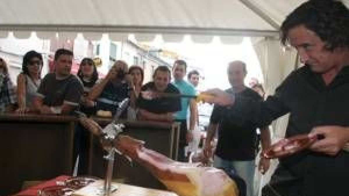 Florencio Sanchidrián cortando jamón en una de las carpas instaladas en las calles de Toral