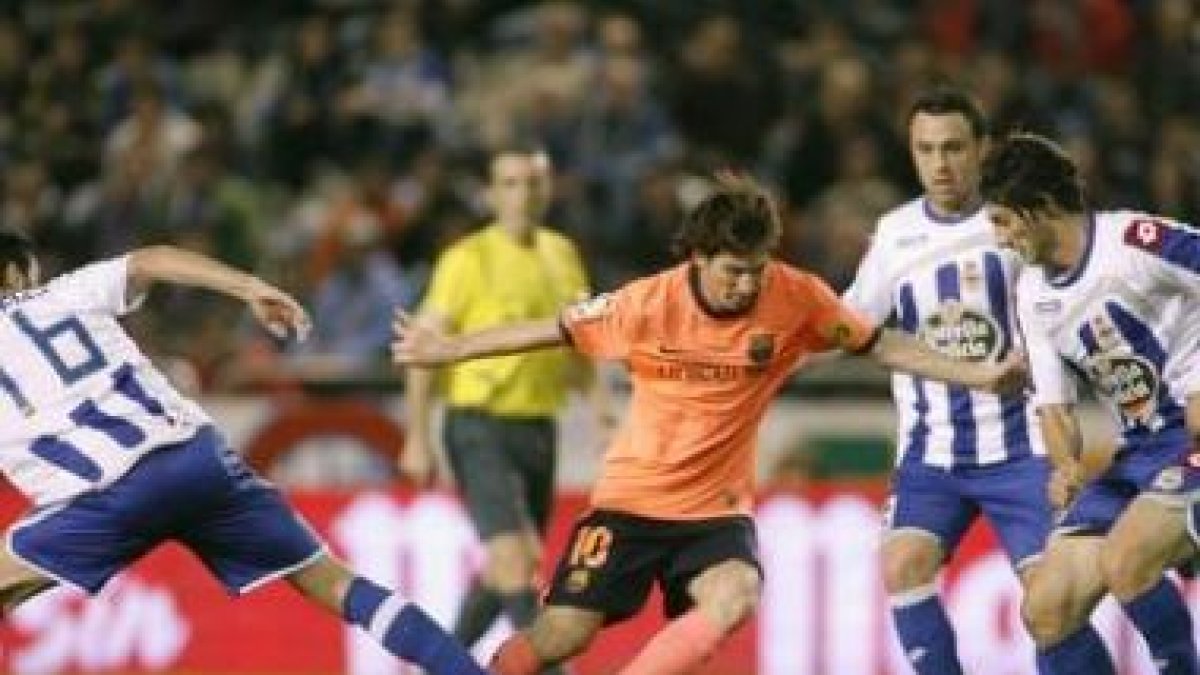 Messi, autor de dos goles para el Barcelona, intenta superar a dos rivales deportivistas.