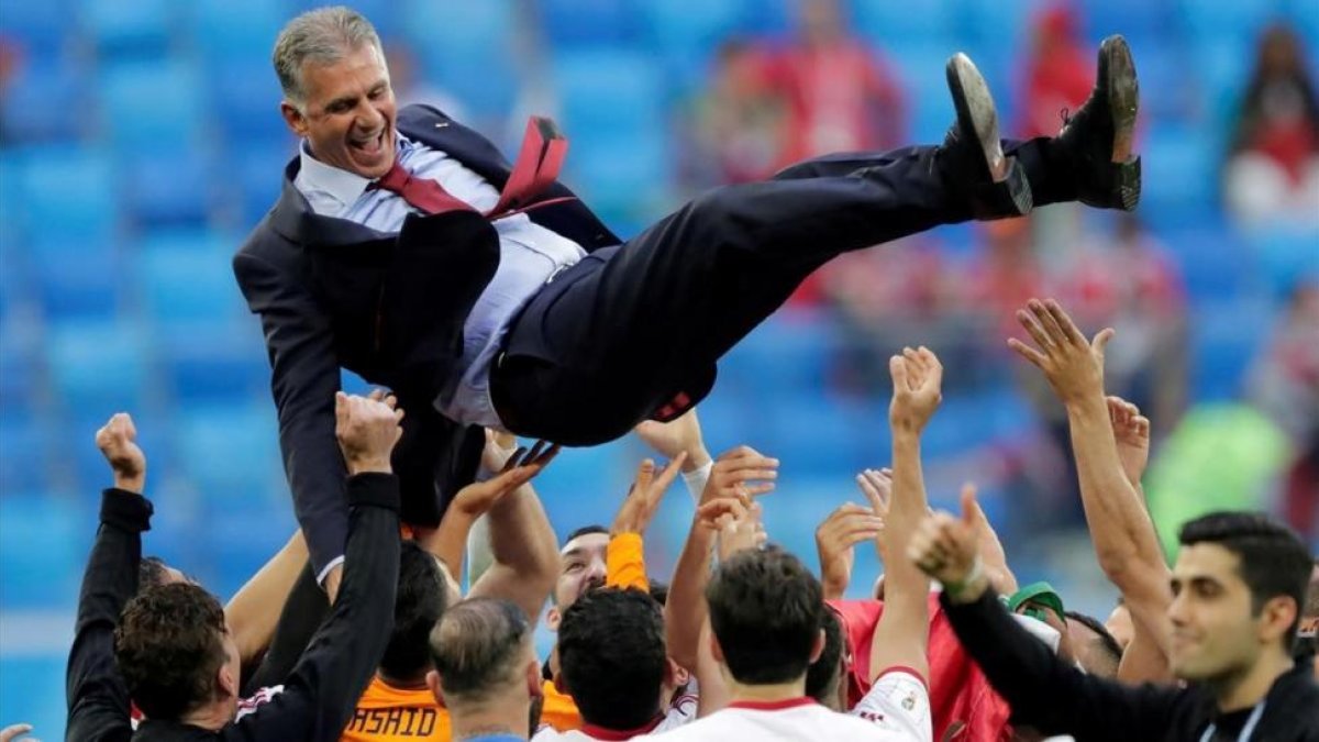 Carlos Queiroz, manteado por sus jugadores después del triunfo contra Marruecos.
