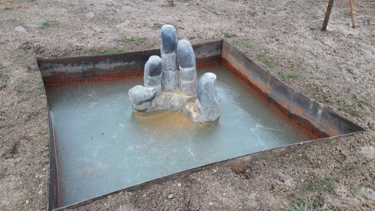 La mano del Celorio, la escultura que Amancio cedió a Paradilla de Gordón, ayer, rodeada de hielo. DL