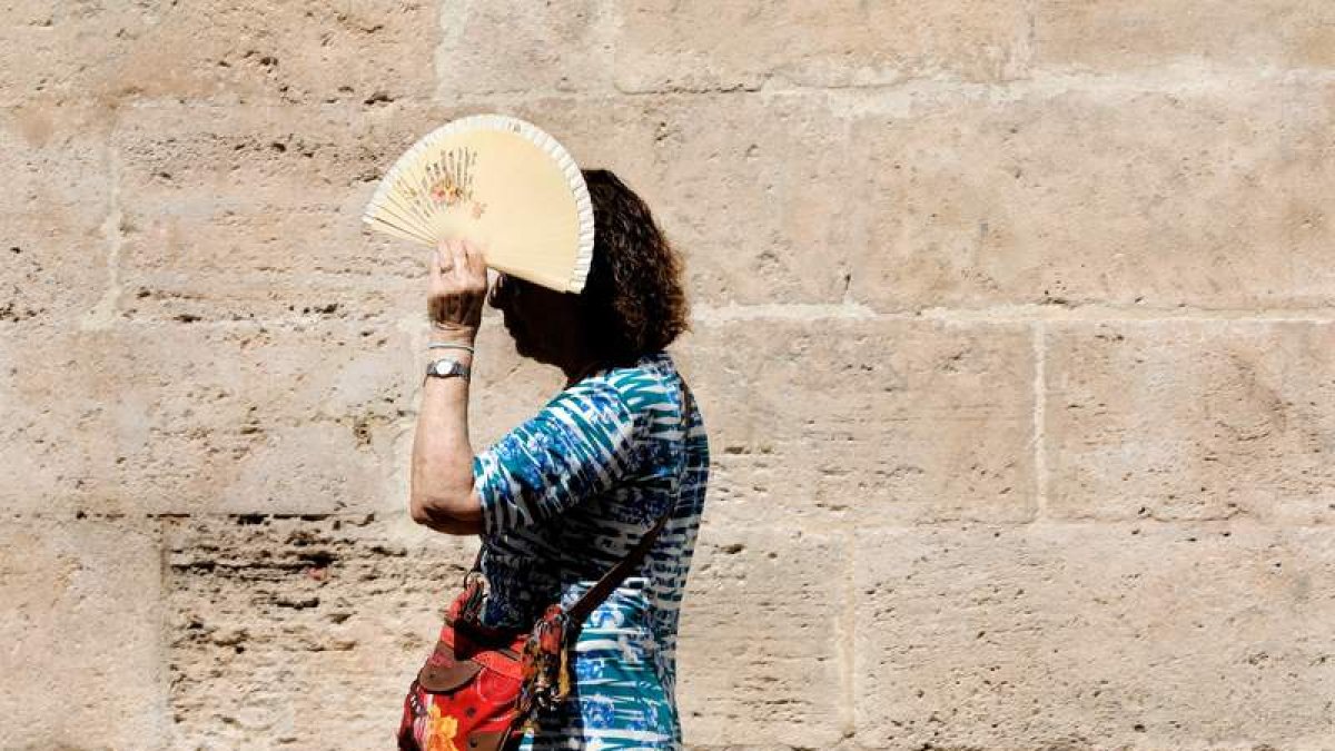 Una persona se protege del Sol en Valencia. JUAN CARLOS CÁRDENAS