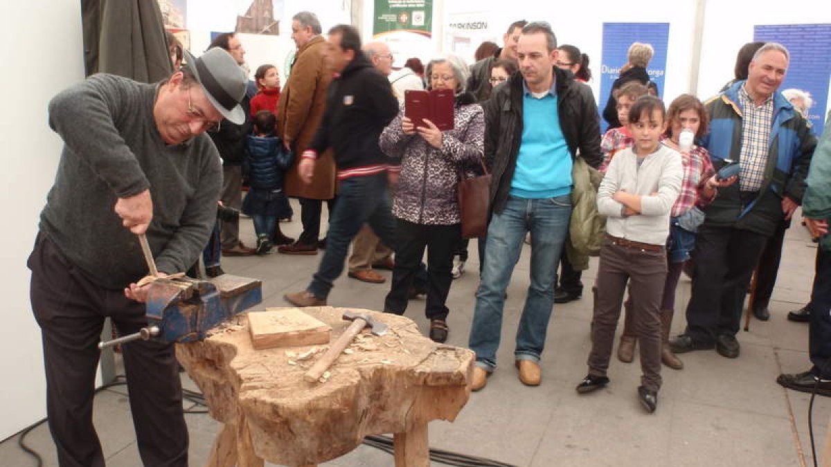 Un artesano talla una cuchara de madera, durante una de las demostraciones que ha acogido la carpa