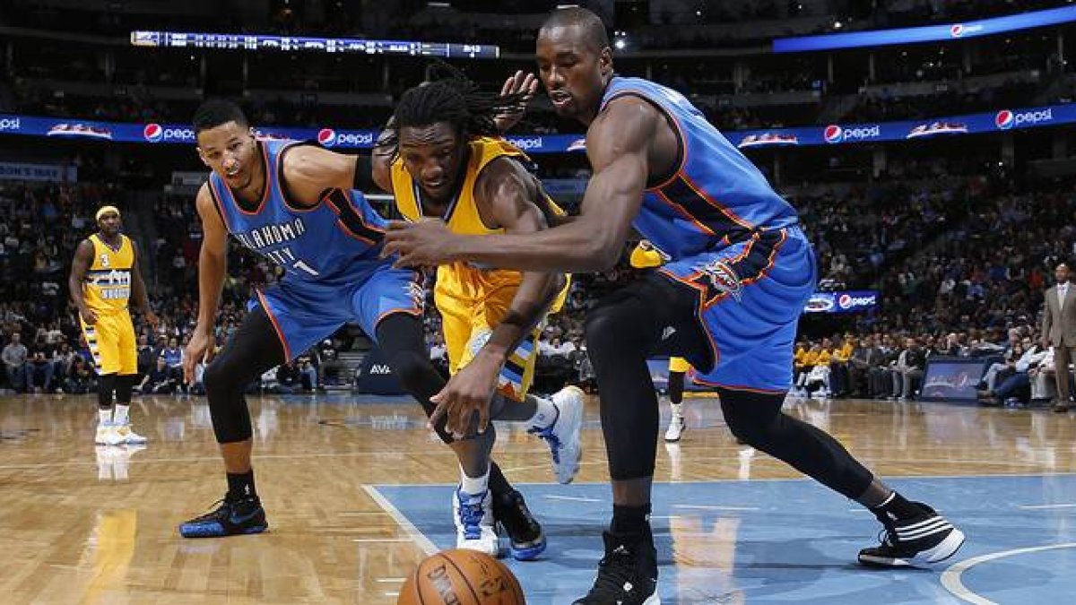 Andre Roberson y Serge Ibaka corren por el balón, en el choque entre los Thunder y los Nuggets en Denver.