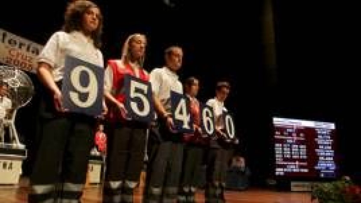 Miembros de la Cruz Roja muestran a los asistentes el primer premio del sorteo