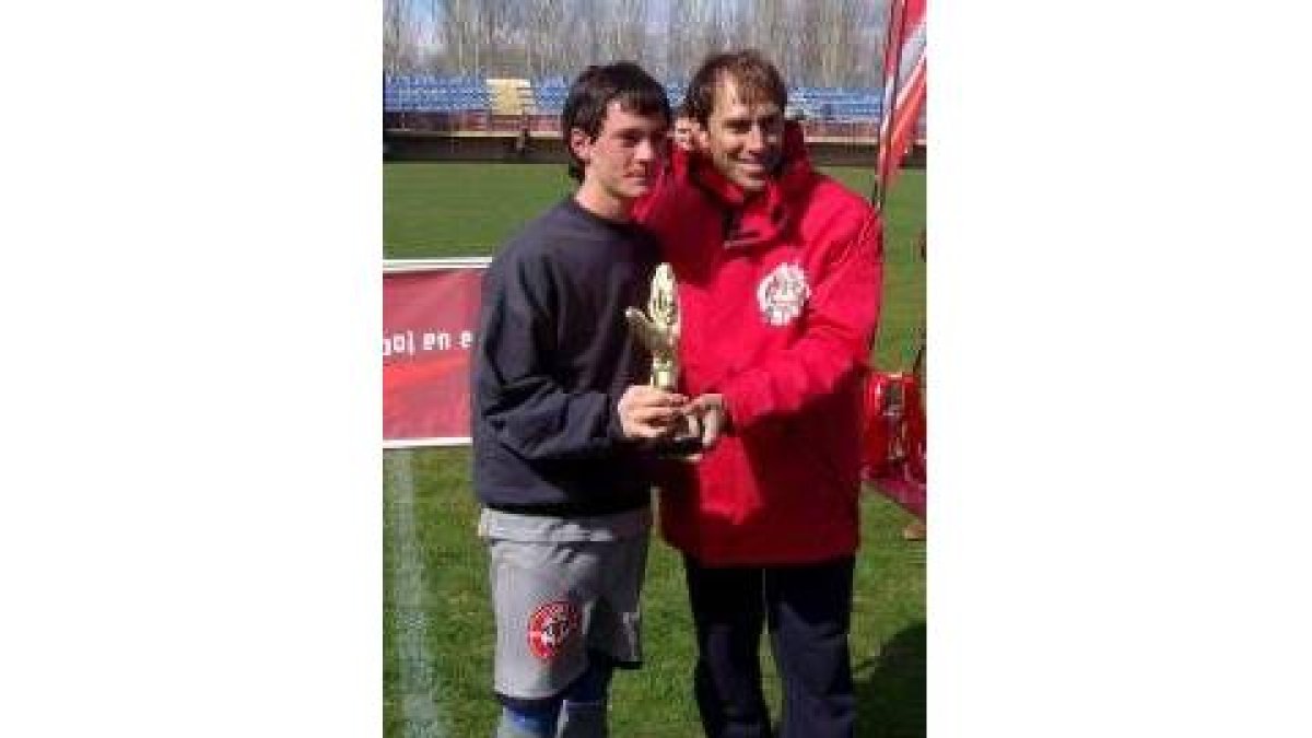 Javi, a la izquierda, recibe el trofeo al mejor meta de Martín Vázquez