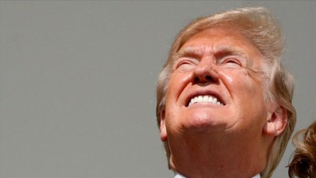 Trump mira el eclipse de Sol a ojo descubierto.
