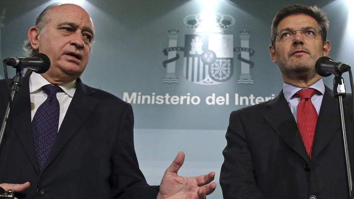 Los ministros de Interior y Justicia tras la reunión con el socialista Antonio Hernando.