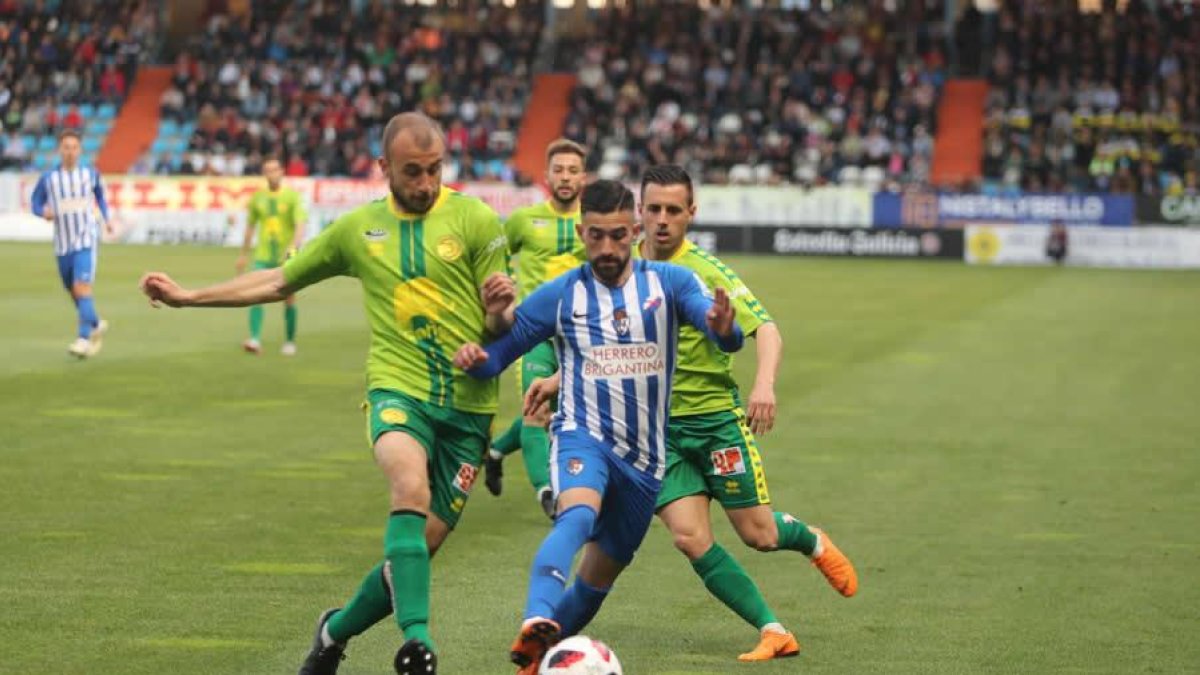 Dani Pichín, con el balón en los pies, se va de dos contrarios en un lance del encuentro disputado en El Toralín.