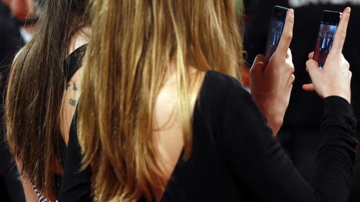 Dos mujeres con sendos teléfonos móviles. JAVIER ETZEZARRETA